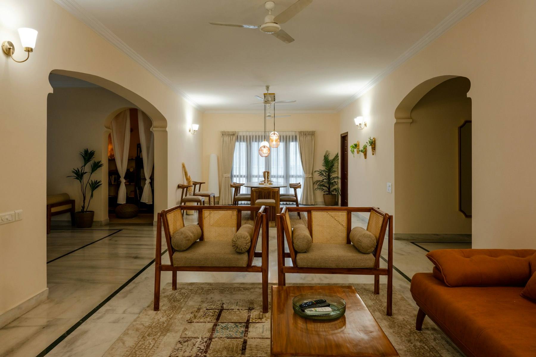 A warm living room with wooden sofas with cane backs